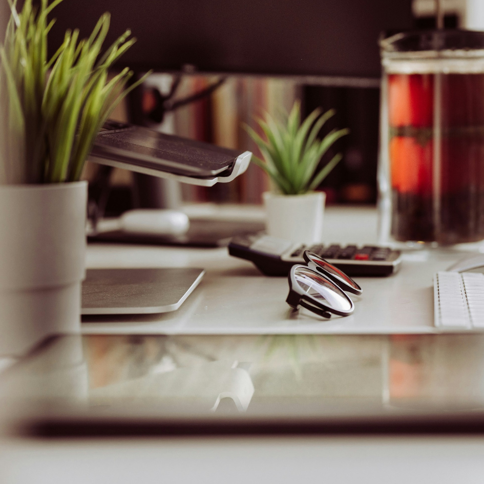 Bureau avec ordinateur, lunettes et théière pour vous accueillir autour d'un thé ou d'un café
